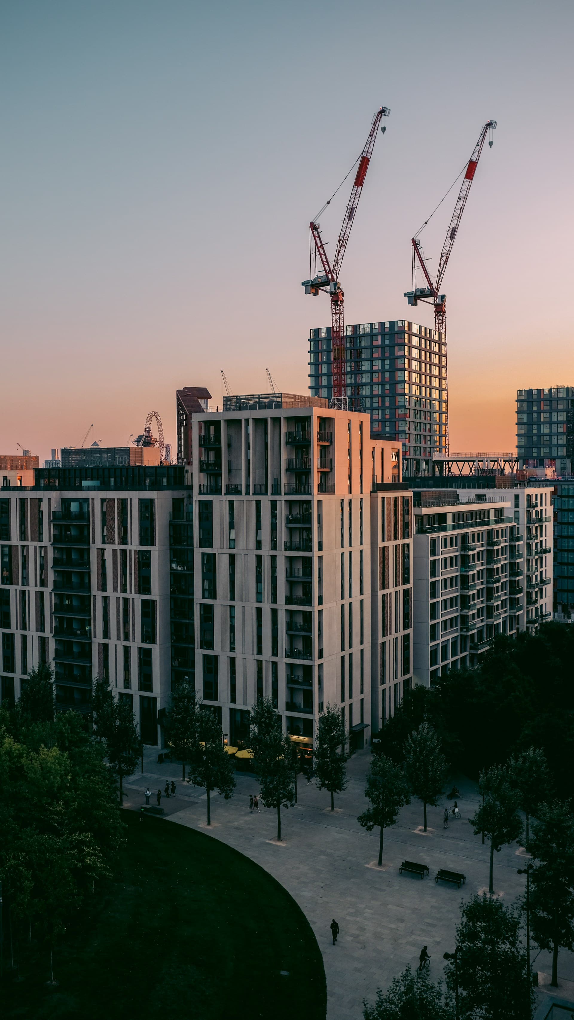 A tall building with cranes in the background